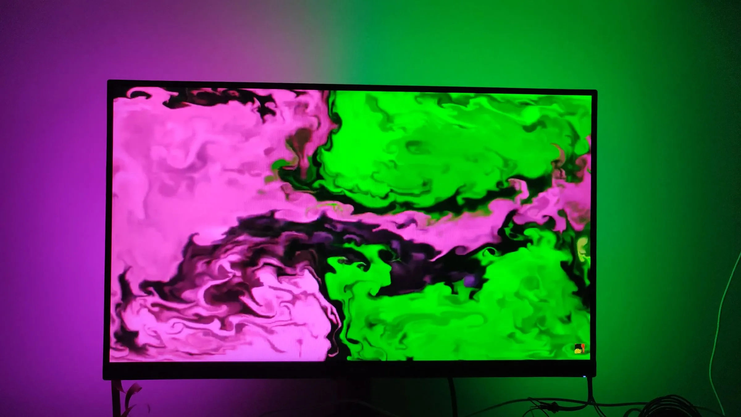 A monitor glowing onto the wall, LEDs mirroring the on-screen colors