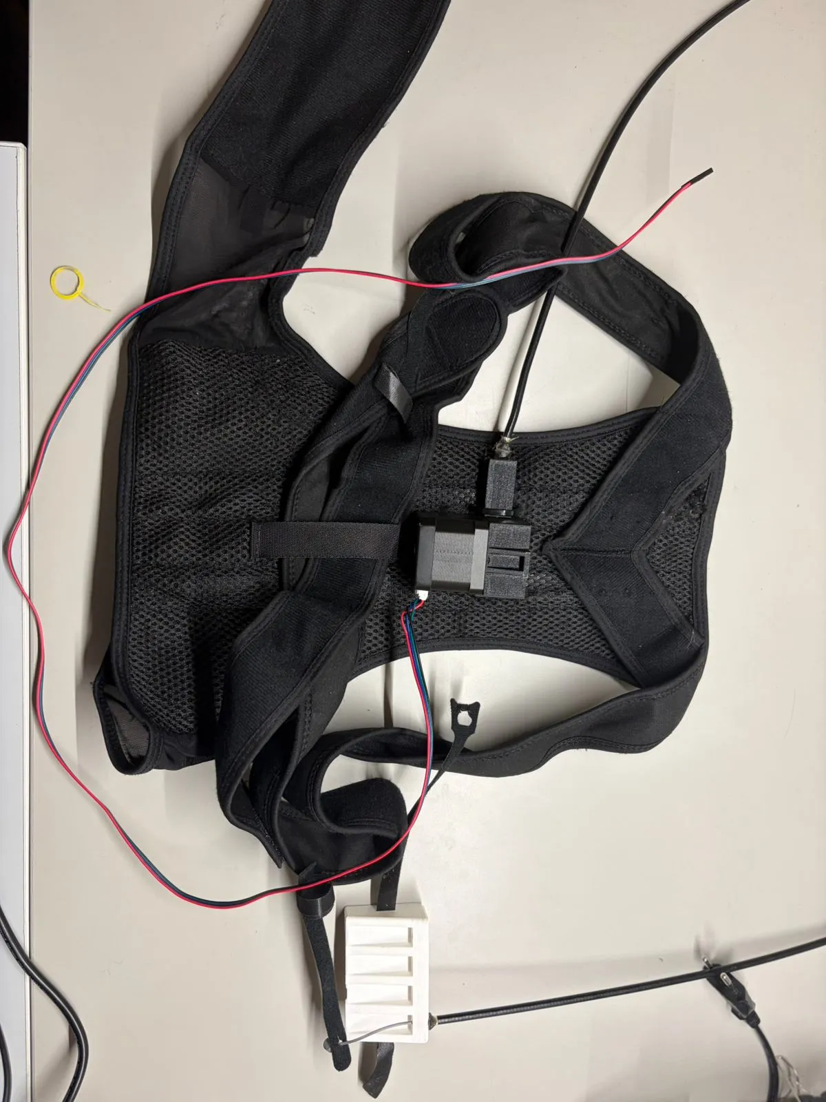 The back-brace frame in its stepper-motor version, steel cables routed toward each finger